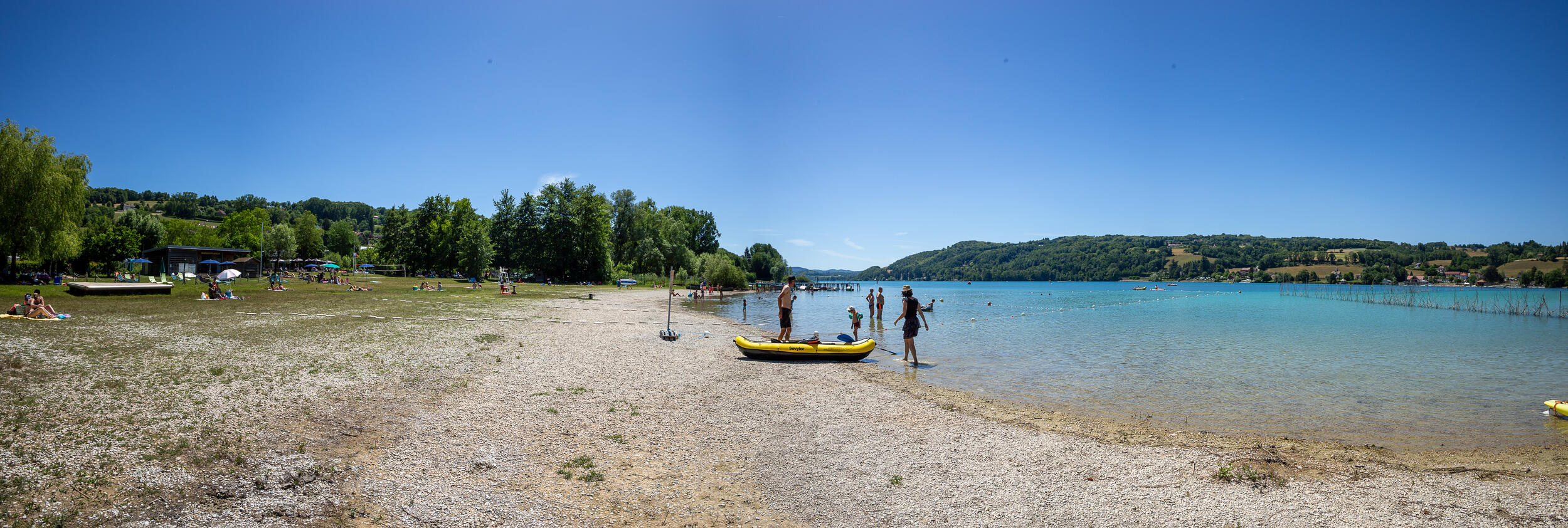 Famille avec bateau gonflable à la plage du Lac de Paladru, eaux turquoise du camping Détente et Clapotis