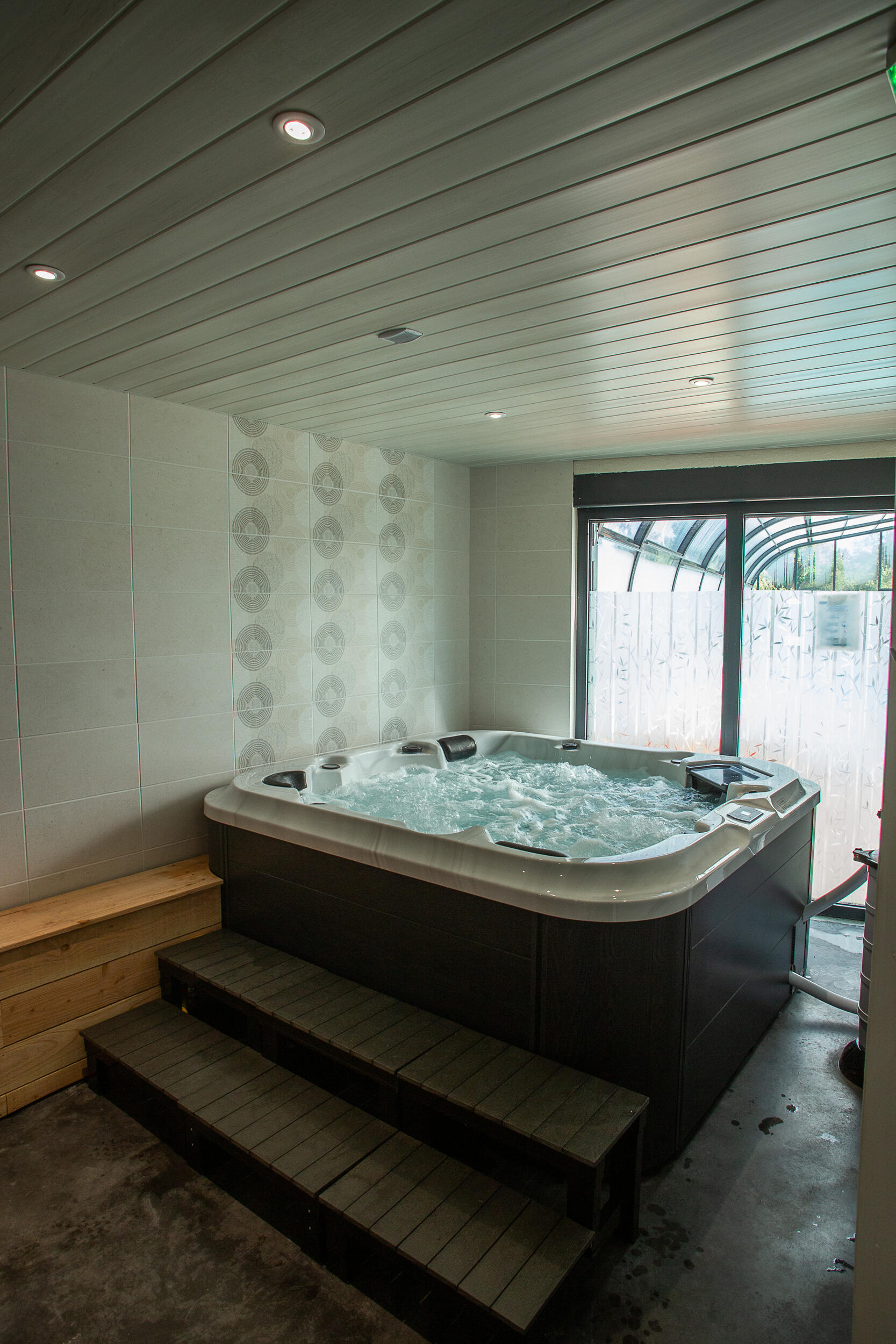Espace détente avec sauna et jacuzzi au camping du Lac de Paladru 4 Vue d'ensemble du jacuzzi et de l'espace détente du camping au lac de Paladru