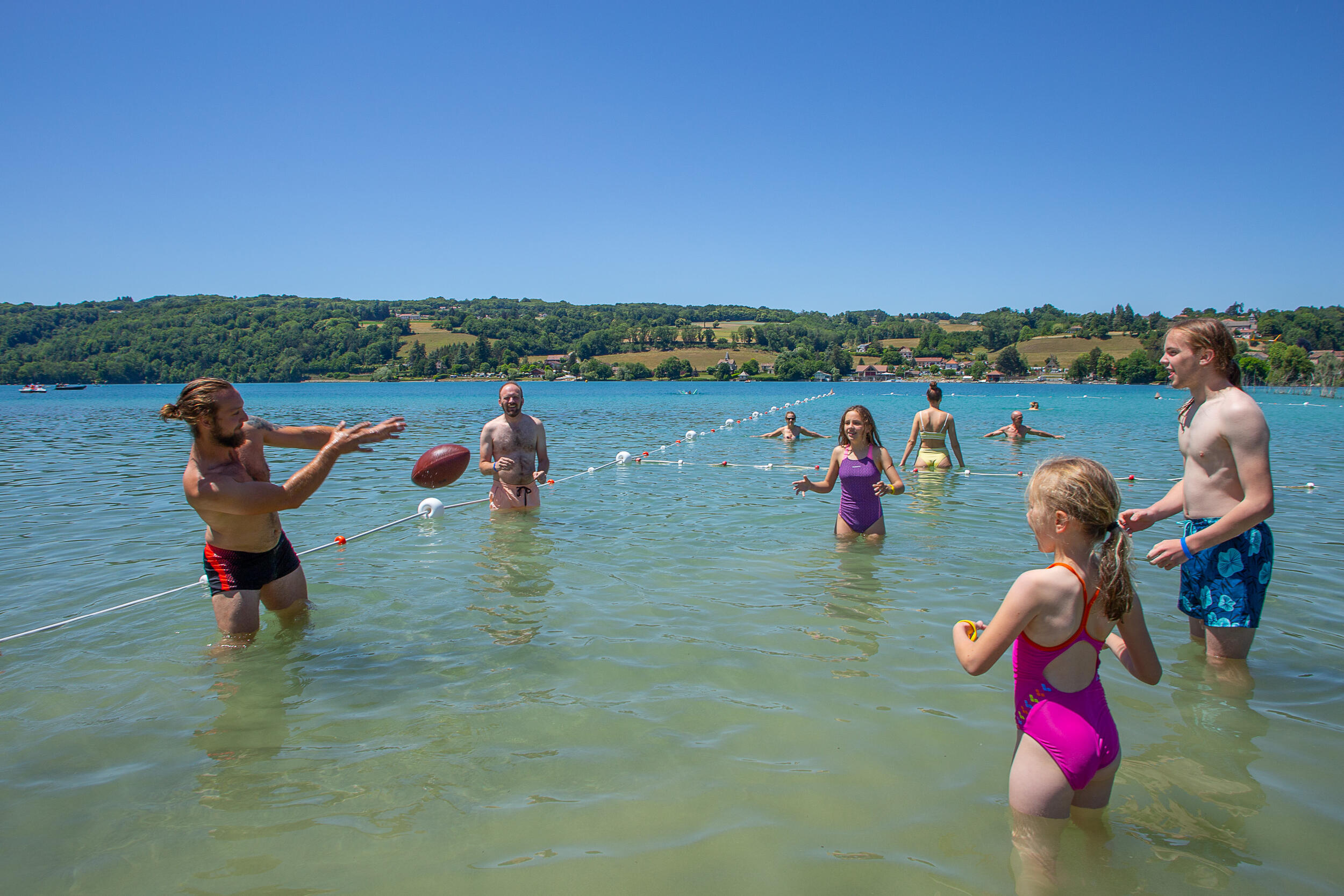Jeux collectifs avec ballon dans le lac de Paladru au club enfants du camping